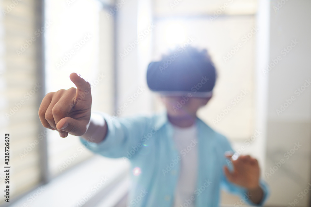 Horizontal shot of unrecognizable boy using VR headset pointing finger at something, copy space Horizontal shot of unrecognizable boy using VR headset pointing finger at something, copy space