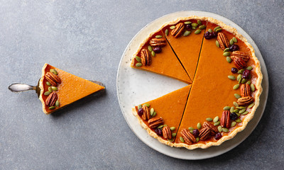 Pumpkin pie on a plate. Grey background. Close up. Top view.