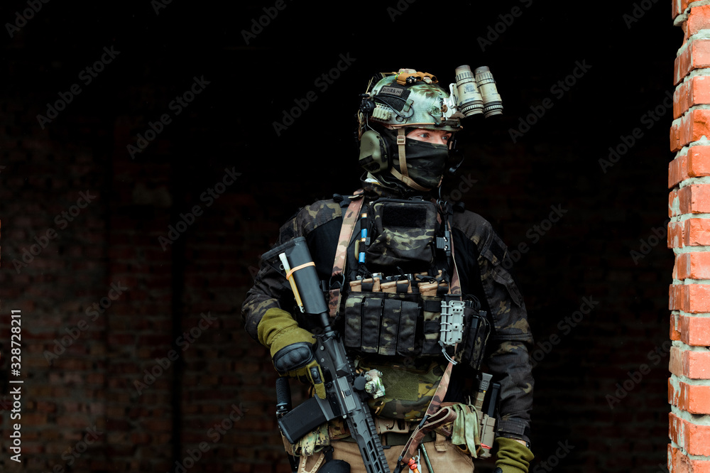 Military man in black uniform with machinegun. Soldier stand in the broken building. Horizontal photo. Military man in black uniform with machinegun. Soldier stand in the broken building. Horizontal photo.