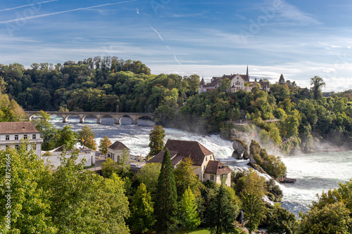 Rheinfall the large waterfall surround with green forest and blue sky background view from Neuhausen am Rheinfall railway station in switzerlad photo