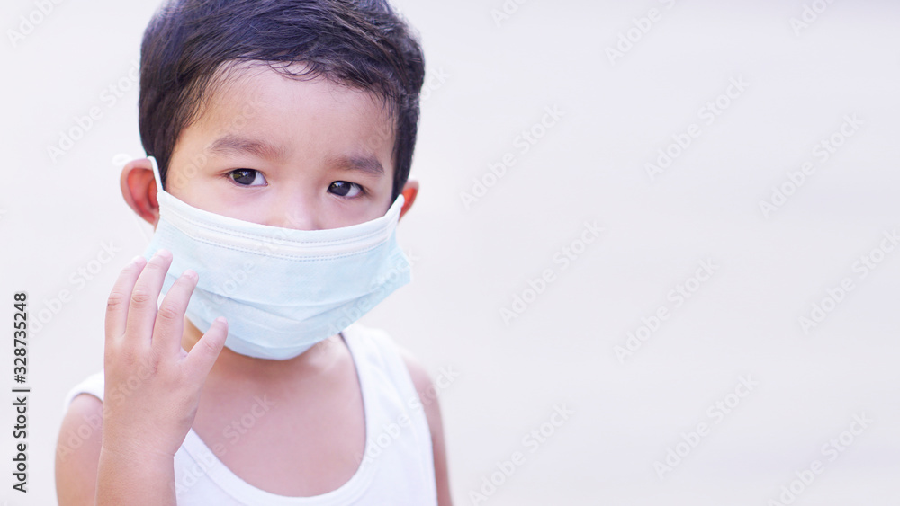 Portrait of cute little Asian 2 -3 years old toddler baby boy so sad face. Child wearing protective medical mask. Virus or PM 2.5 concept. 