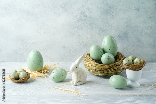 Photography Easter holiday decorations with easter eggs, bunny and bird nest on wooden table