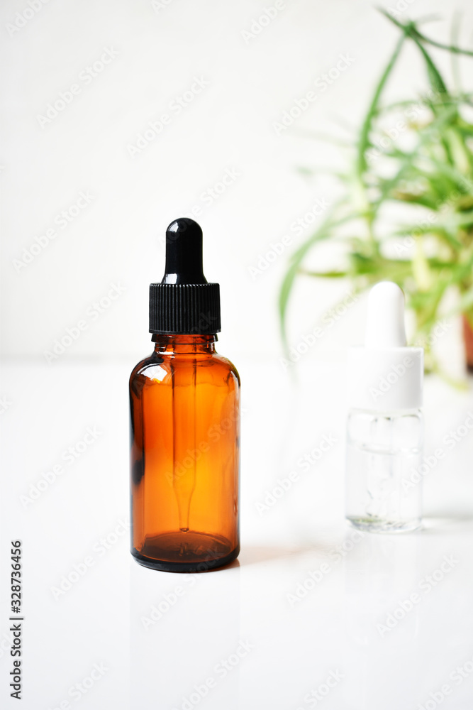Various glass bottles for cosmetics, natural medicine , essential oils or other liquids on a white background, top view. Organic Various glass bottles for cosmetics, natural medicine , essential oils or other liquids on a white background, top view. Organic