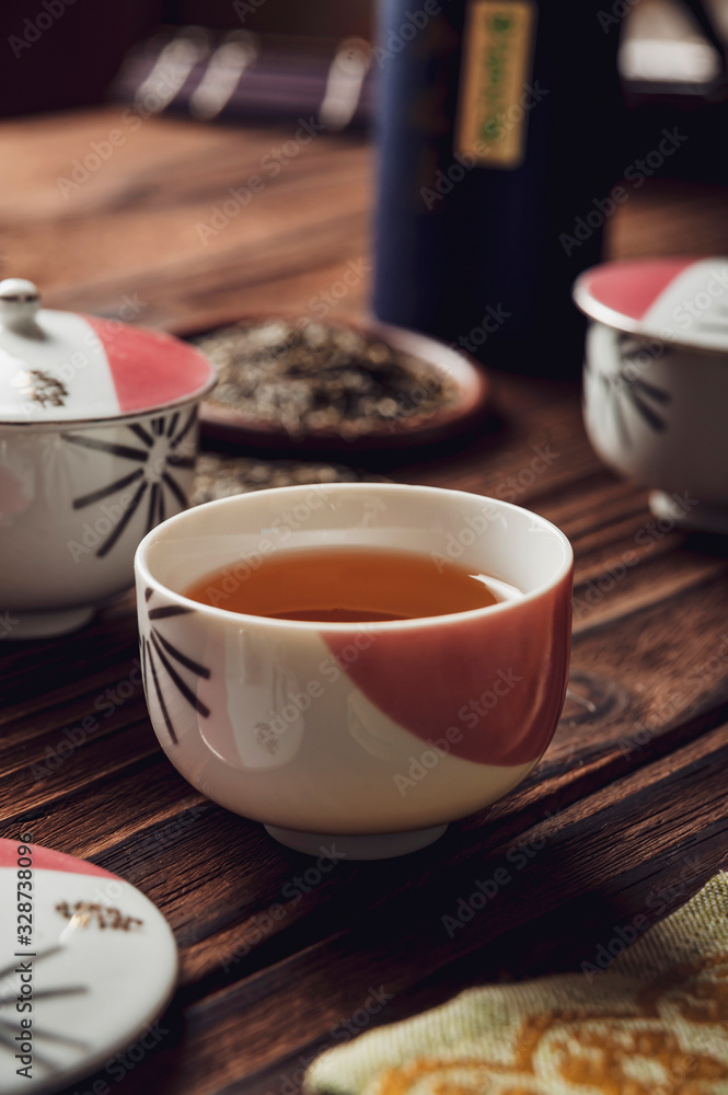 Japanese tea into asian porcelain cup on wood table Japanese tea into asian porcelain cup on wood table