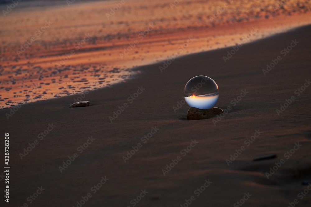 Obraz premium Tramonto sulla spiaggia salentina con sfera di cristallo