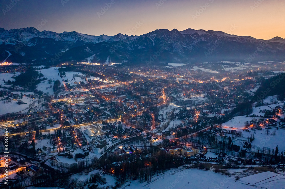 Beautiful illuminated Zakopane city after dusk in winter, aerial view