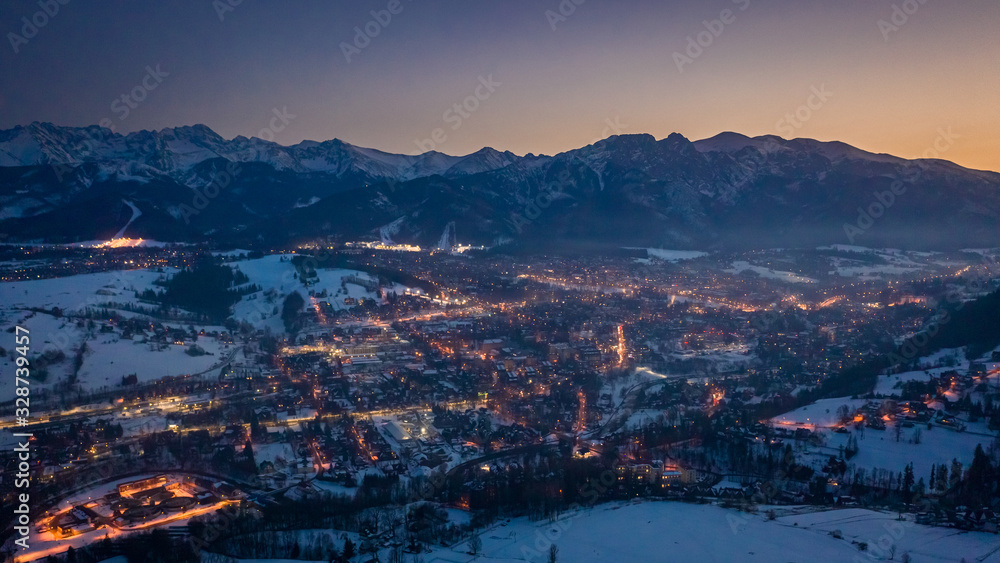 Beautiful illuminated Zakopane city in winter at night, aerial view