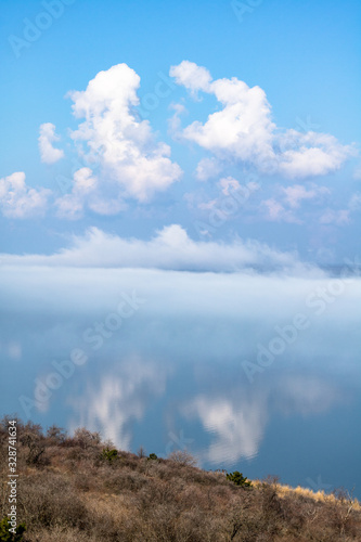 fog above the lake  clouds at sky and its reflection in the water