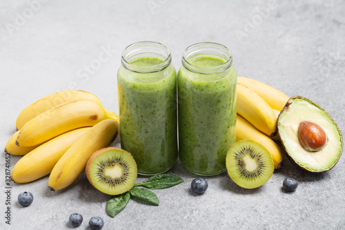 Green healthy smoothie in glass jar: avocado, banana, kiwi, spinach and blueberries