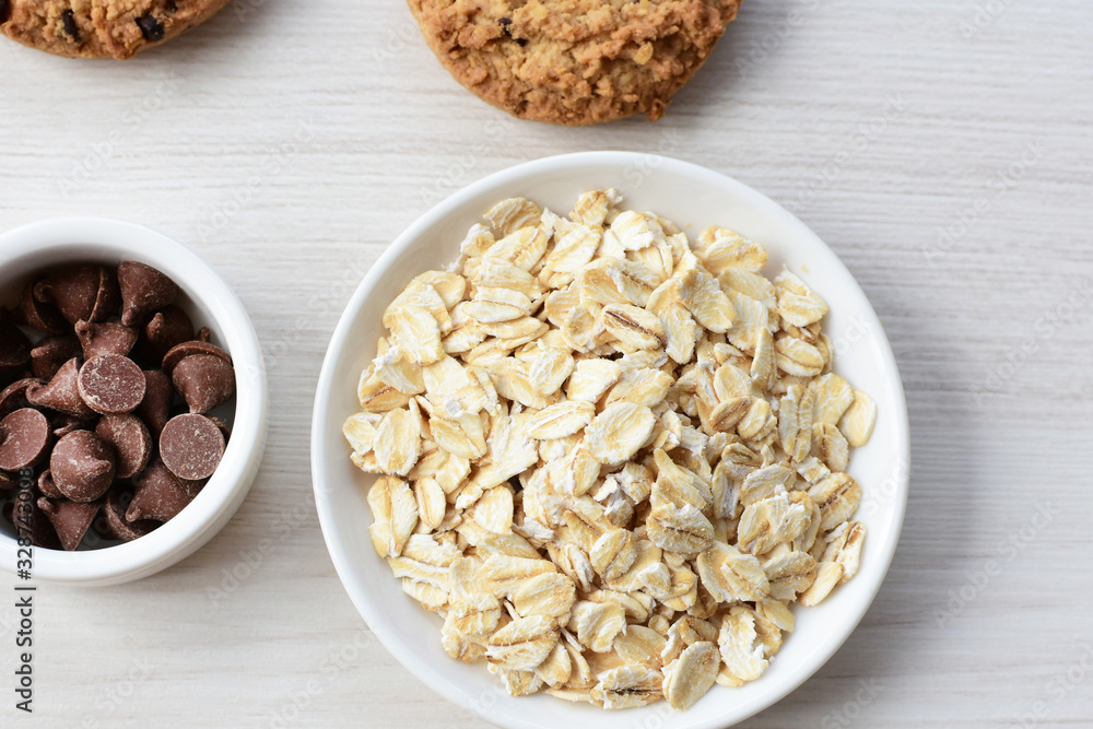 Oatmeal cookies and chocolate chips on light background Oatmeal cookies and chocolate chips on light background