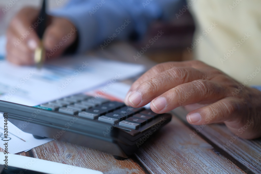 Close up of senior man using calculator 