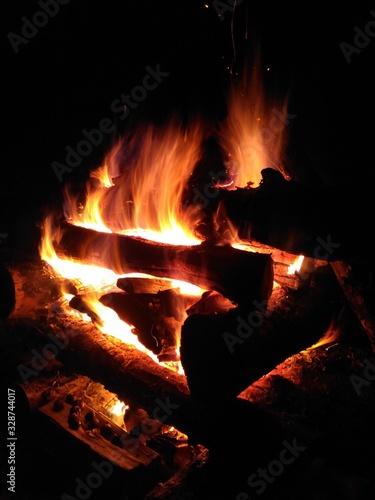 Bewitching flame of fire. Bonfire at night. Orange flame on a dark background.