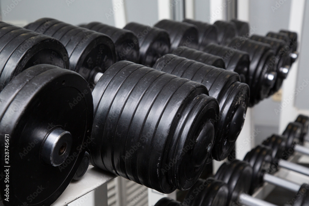 Black dumbbells for fitness classes in the gym. Black dumbbells for fitness classes in the gym.
