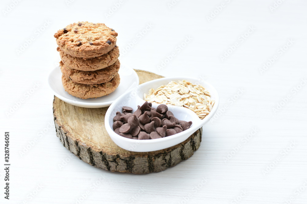 Oatmeal cookies and chocolate chips on light background Oatmeal cookies and chocolate chips on light background
