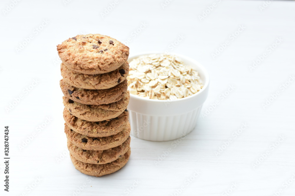 Oatmeal cookies and chocolate chips on light background Oatmeal cookies and chocolate chips on light background