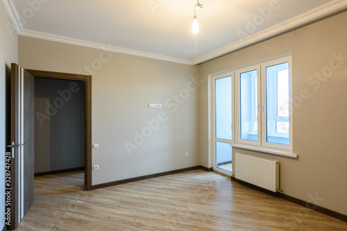 The interior of the room is unfurnished with new renovations  the front door and the balcony exit