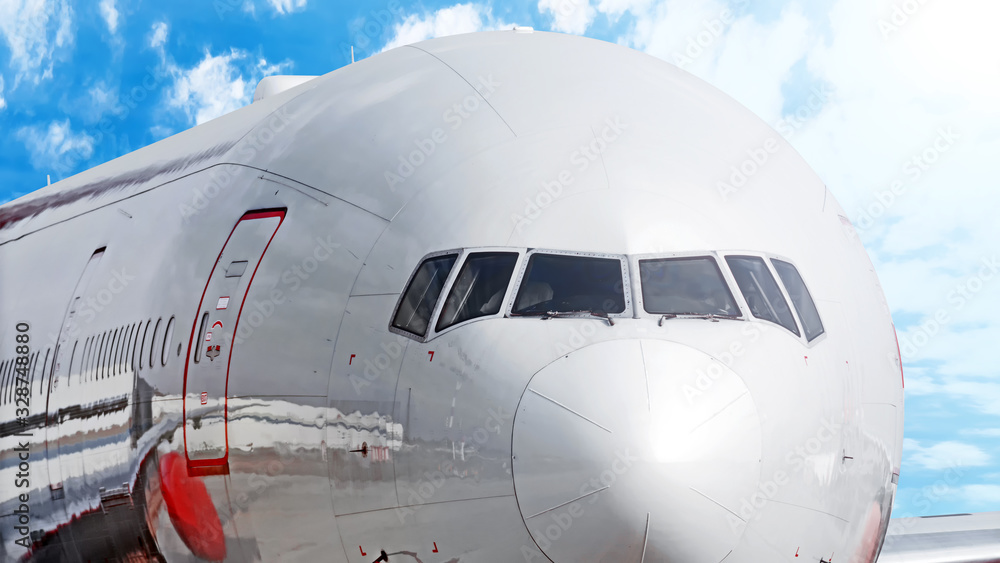 Naklejka premium modern airplane front wide view against clouds blue sky background passenger plane closeup reference for banner design jet aircraft in details aviation concept