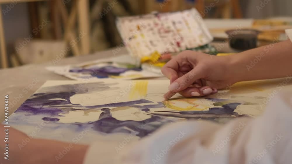 Painting class. Skill development. Female hand creating abstract artwork with wax crayon on canvas. Painting class. Skill development. Female hand creating abstract artwork with wax crayon on canvas.