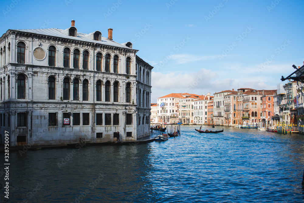View of the Grand Canal in Venice during sunset. Ttraditional gondolas and boats with passengers.
