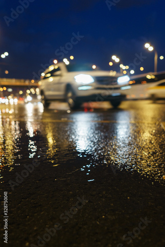 Blurred modern car in motion on the night streets. Low point shooting. © Evgenii Starkov
