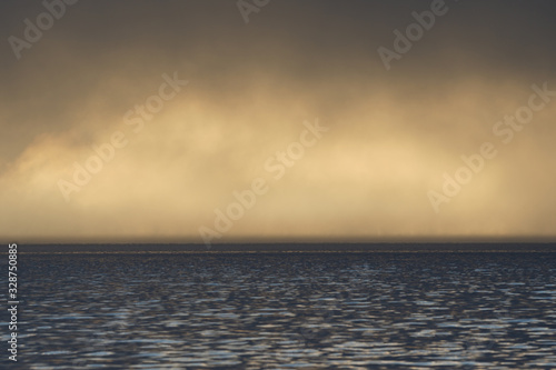 Fog and clouds hovering over the water.