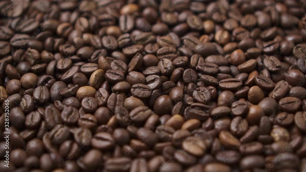 Dark roasted coffee beans move in a circle. Close up. Dark roasted coffee beans move in a circle. Close up.
