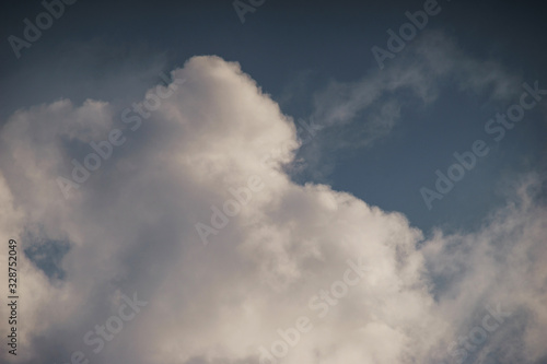 Large white cumulus clouds against a blue sky. © Evgenii Starkov