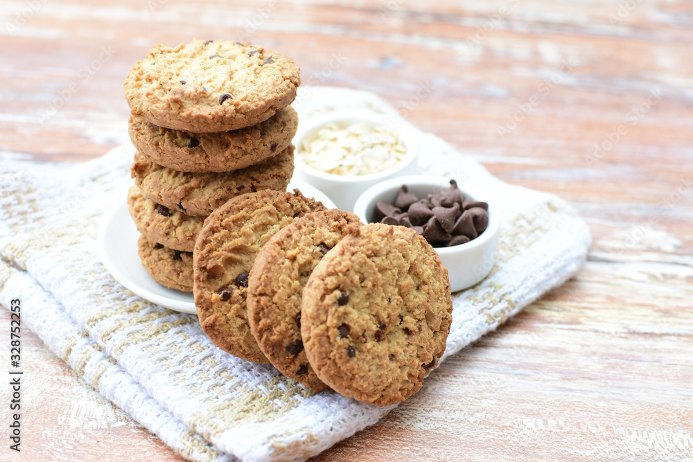 Fototapeta premium Oatmeal cookies and chocolate chips on light background