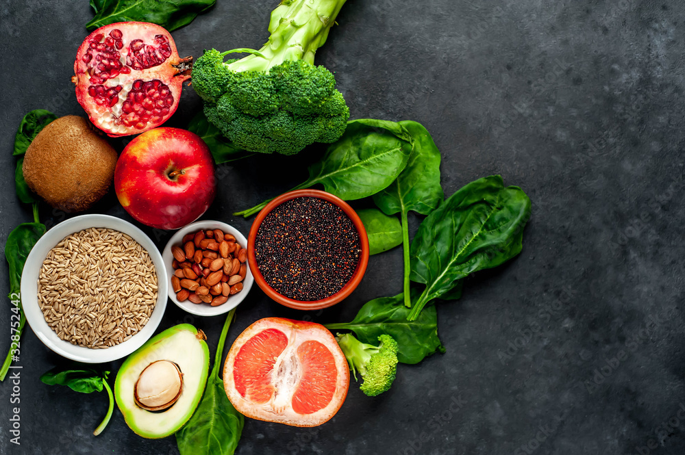 Selection of healthy food: fruits, seeds, cereals, superfoods, vegetables, leafy vegetables on a stone background. Healthy food for humans. Copy space for your text. Selection of healthy food: fruits, seeds, cereals, superfoods, vegetables, leafy vegetables on a stone background. Healthy food for humans. Copy space for your text.