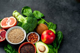  Selection of healthy food: fruits, seeds, cereals, superfoods, vegetables, leafy vegetables on a stone background. Healthy food for humans. Copy space for your text.