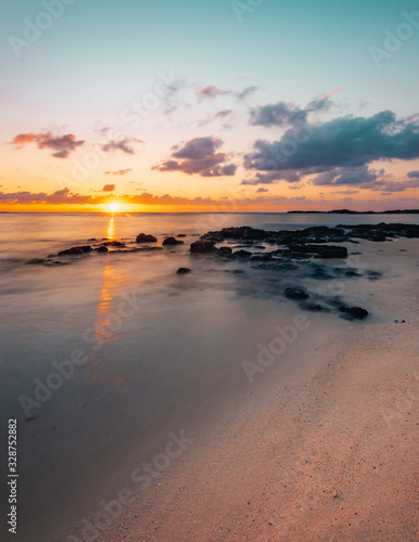 sunset on beach in Mauritius in the Indian Ocean. on the beach with a couple of stones and a picturesque sky
