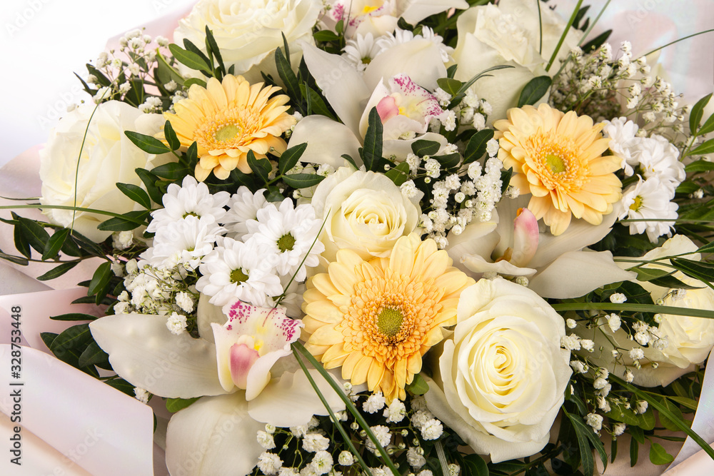 Delicate bouquet of flowers with white roses, orchids and yellow daisies. Delicate bouquet of flowers with white roses, orchids and yellow daisies.