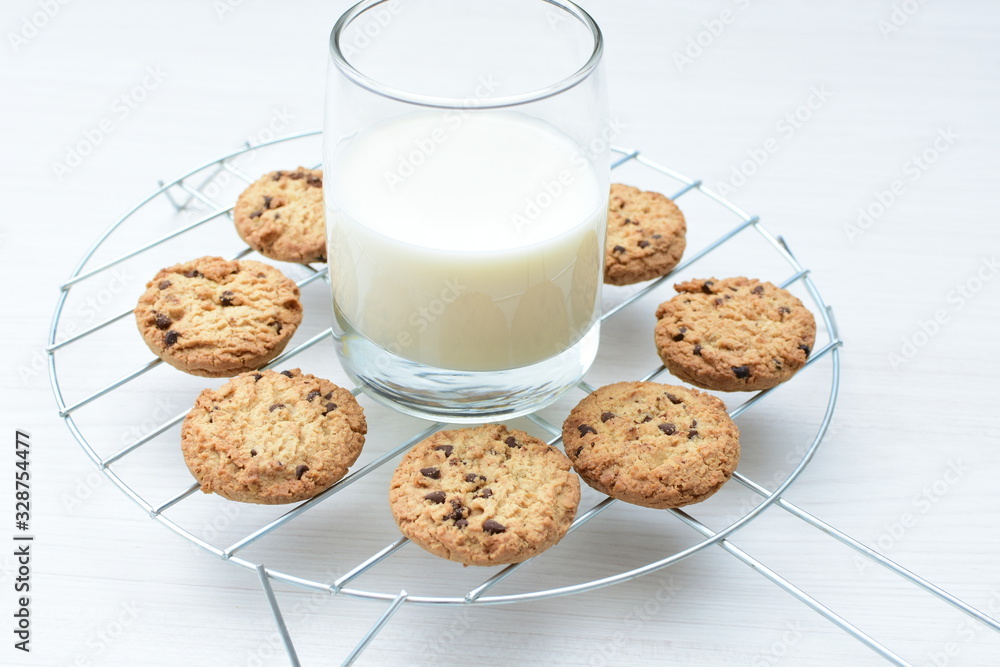 Oatmeal cookies and chocolate chips accompanied by glass of milk Oatmeal cookies and chocolate chips accompanied by glass of milk