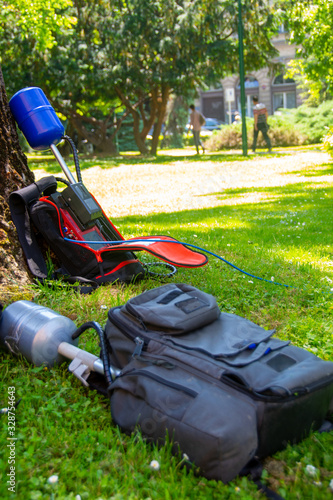 Equopment of a news crew in a park left on grass while taking interview photo