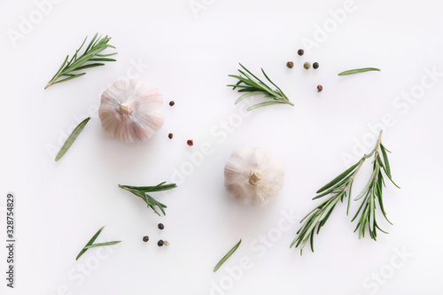 Garlic and rosemary on white background. Flat lay