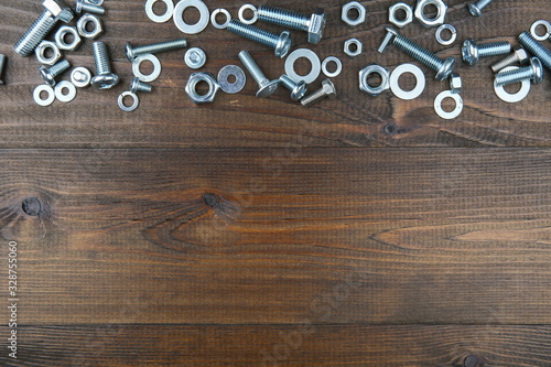 bolts and nuts on a dark wooden background view from above with copy space