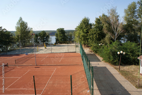 Tennis court and volleyball court in nature. © Elena Shap