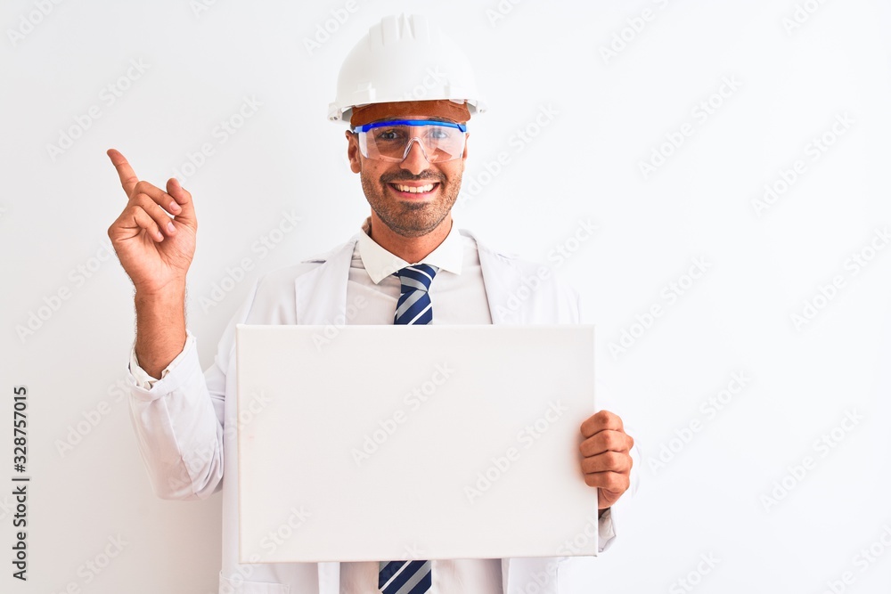 Young chemist man wearing security helmet holding signboard over isolated background very happy pointing with hand and finger to the side Young chemist man wearing security helmet holding signboard over isolated background very happy pointing with hand and finger to the side