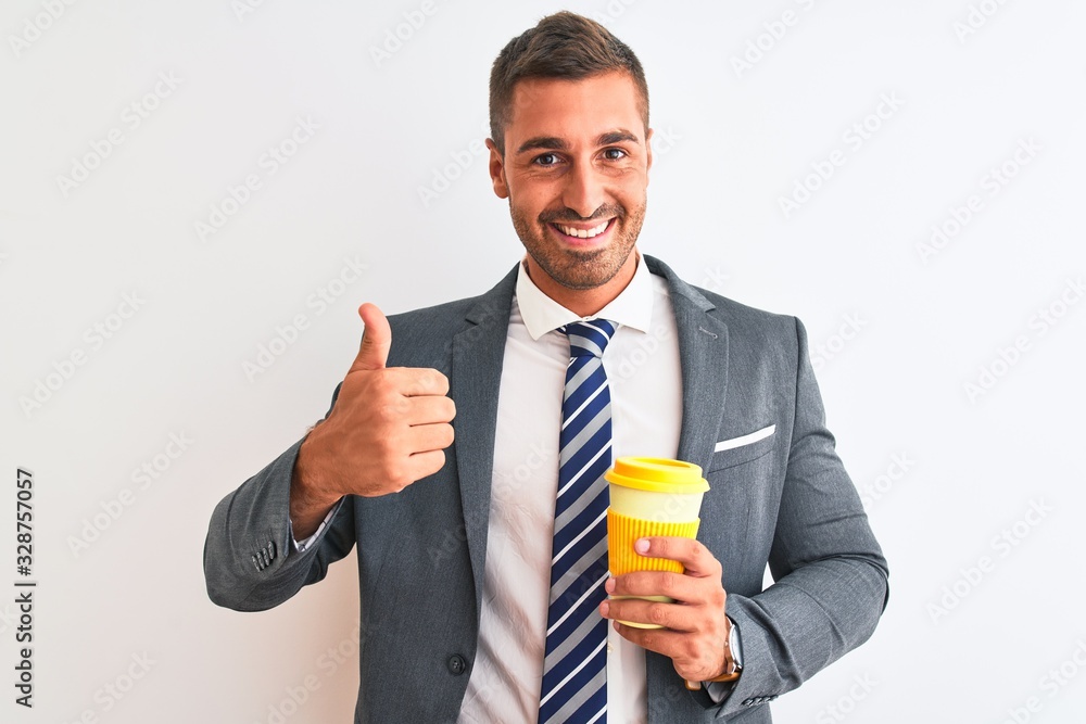 Young handsome business man drinking take away coffee over isolated background happy with big smile doing ok sign, thumb up with fingers, excellent sign Young handsome business man drinking take away coffee over isolated background happy with big smile doing ok sign, thumb up with fingers, excellent sign