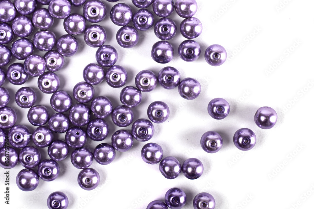 Large lilac colored beads are scattered on a white isolated background Large lilac colored beads are scattered on a white isolated background