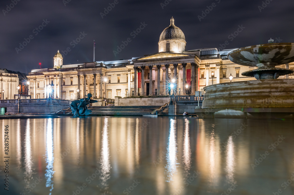 The National Gallery in London, night view over Trafalgar square fountains