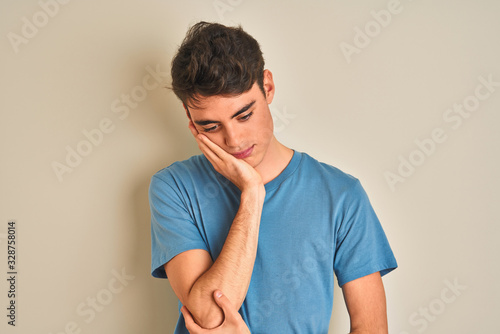 Teenager boy wearing casual t-shirt standing over isolated background thinking looking tired and bored with depression problems with crossed arms.