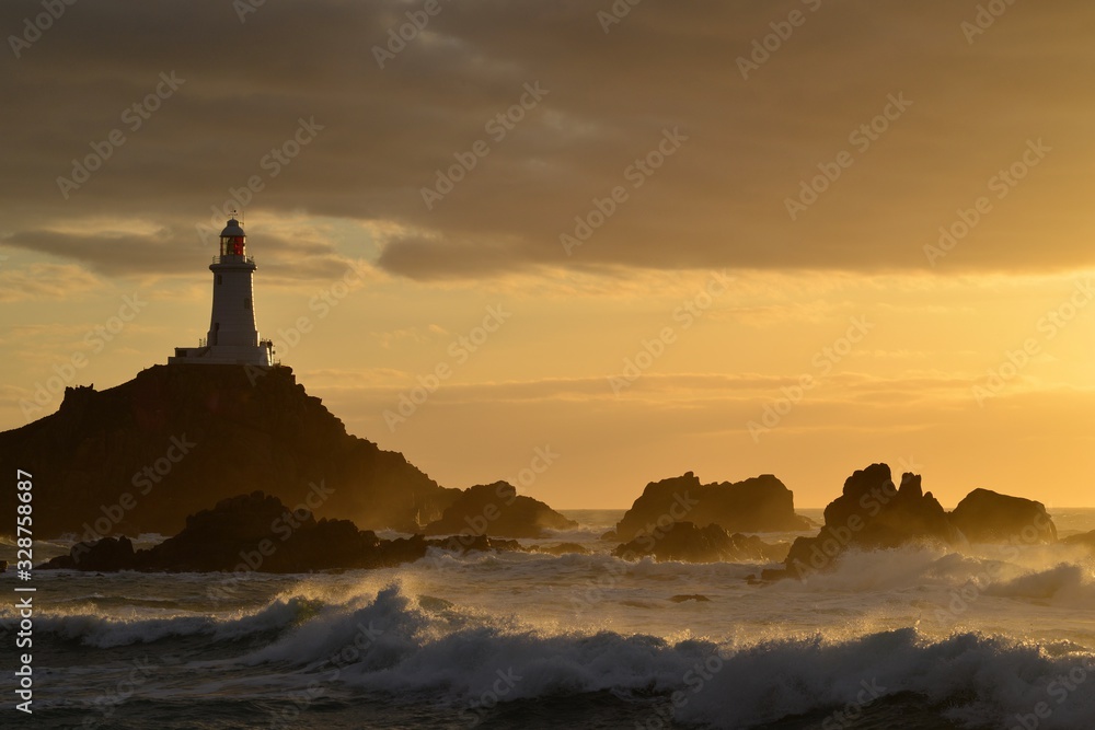 Corbiere lighthouse, Jersey, U.K. Coastal Spring tides at sunset.