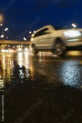 Blurred modern car in motion on the night streets. Low point shooting.