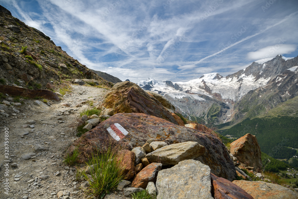 Walking trail from Kreuzboden to Saas-Almagell with incredible views on always white Alps above the Saas-Fee village in Switzerland