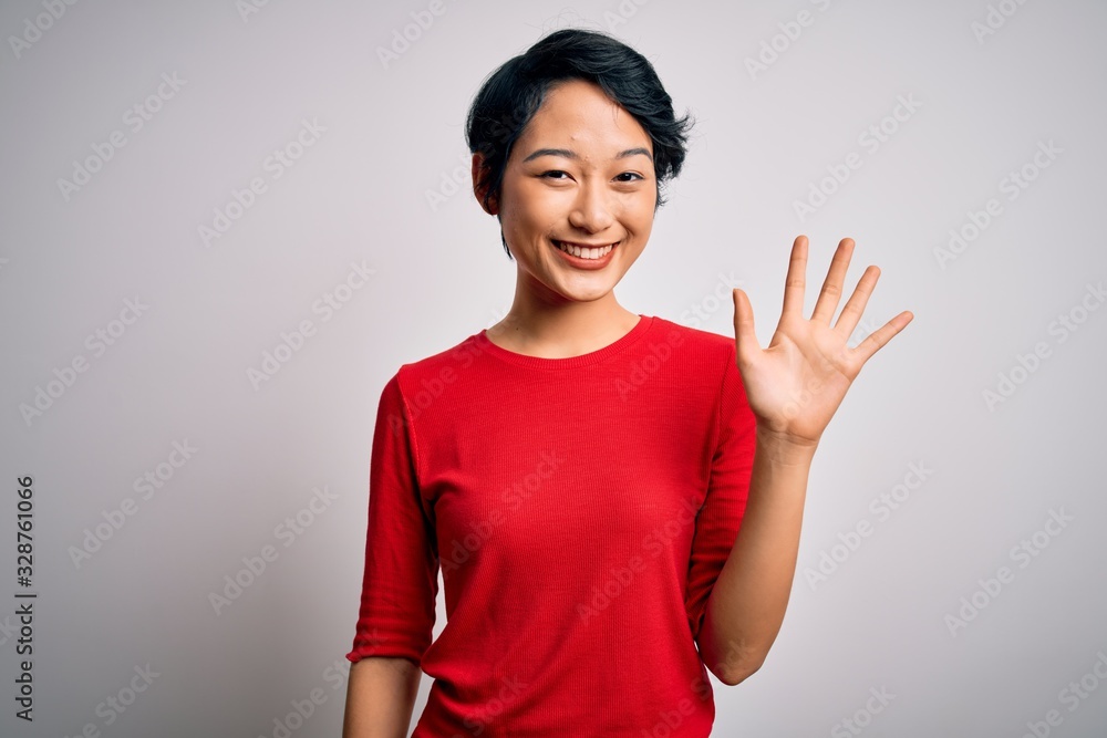 Young beautiful asian girl wearing casual red t-shirt standing over isolated white background showing and pointing up with fingers number five while smiling confident and happy. Young beautiful asian girl wearing casual red t-shirt standing over isolated white background showing and pointing up with fingers number five while smiling confident and happy.
