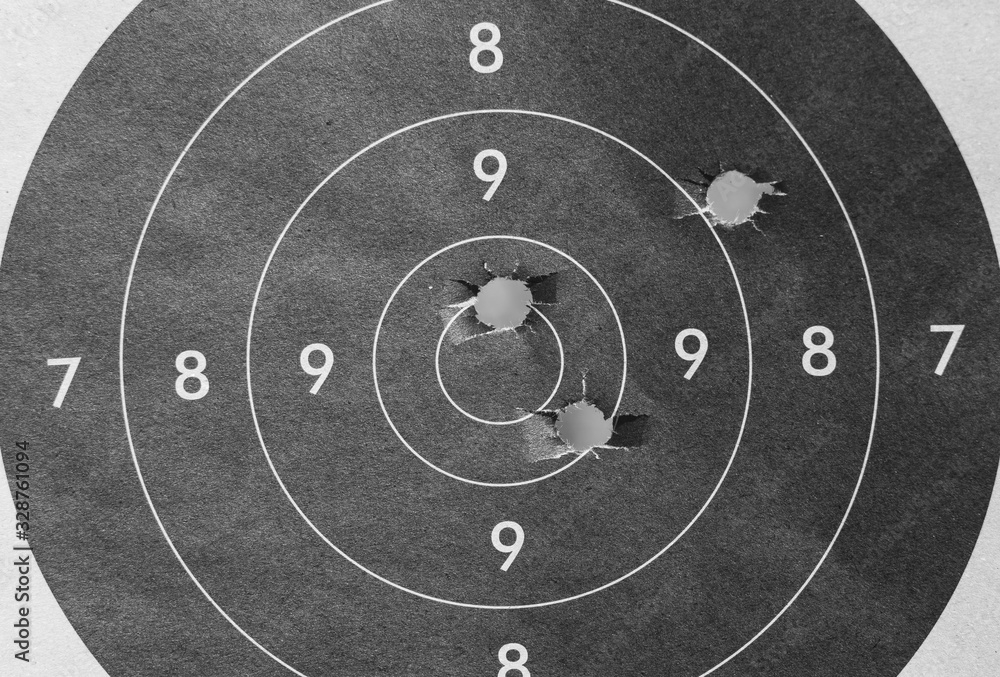 © Zoran - Close up of a shooting target and bullseye with bullet holes
