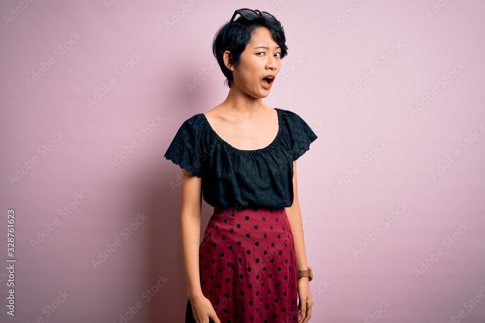 Young beautiful asian girl wearing casual dress standing over isolated pink background In shock face, looking skeptical and sarcastic, surprised with open mouth Young beautiful asian girl wearing casual dress standing over isolated pink background In shock face, looking skeptical and sarcastic, surprised with open mouth