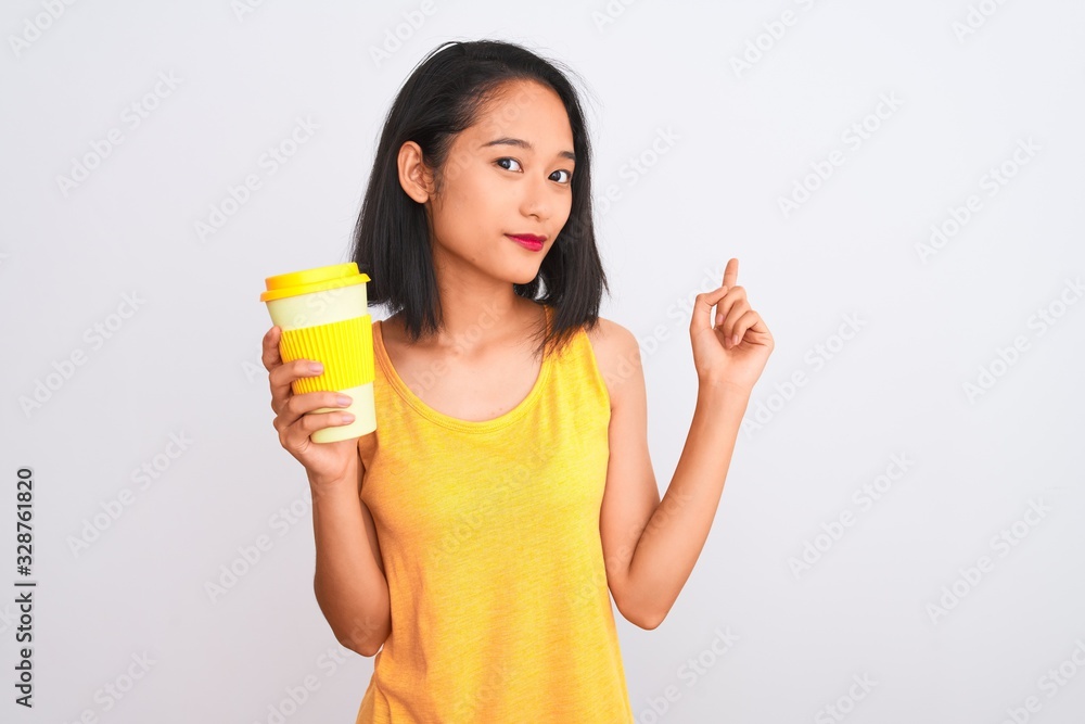 Young chinese woman drinking take away glass of coffee over isolated white background very happy pointing with hand and finger to the side Young chinese woman drinking take away glass of coffee over isolated white background very happy pointing with hand and finger to the side