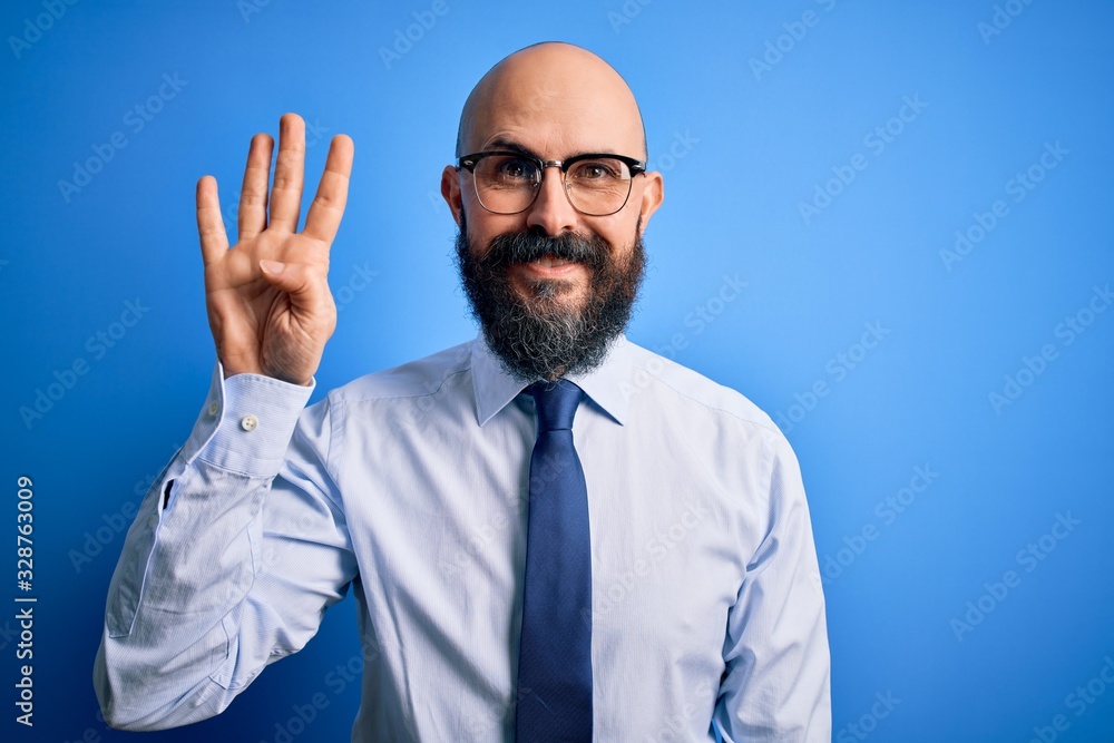 Handsome business bald man with beard wearing elegant tie and glasses over blue background showing and pointing up with fingers number four while smiling confident and happy. Handsome business bald man with beard wearing elegant tie and glasses over blue background showing and pointing up with fingers number four while smiling confident and happy.